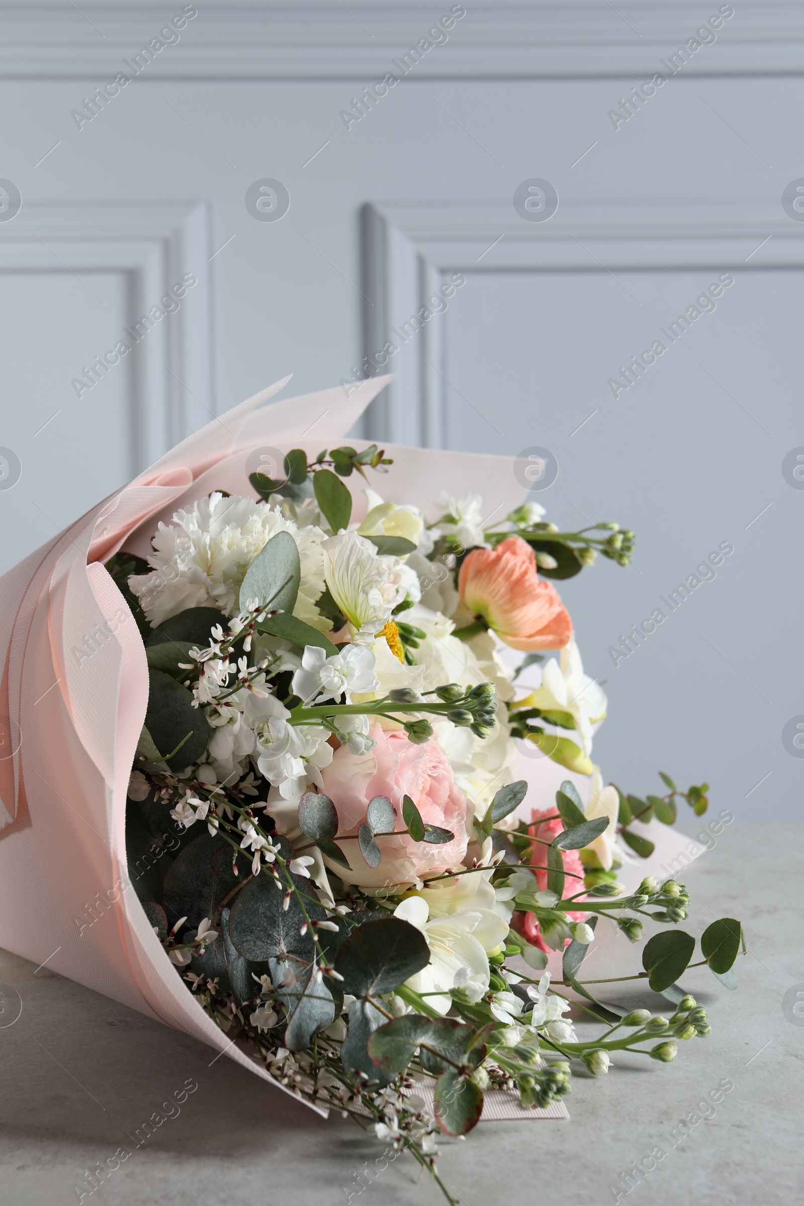 Photo of Bouquet of beautiful flowers on light grey table