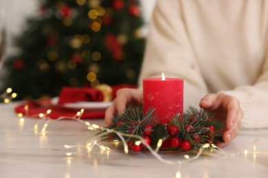 Photo of Woman setting table for Christmas celebration at home, closeup