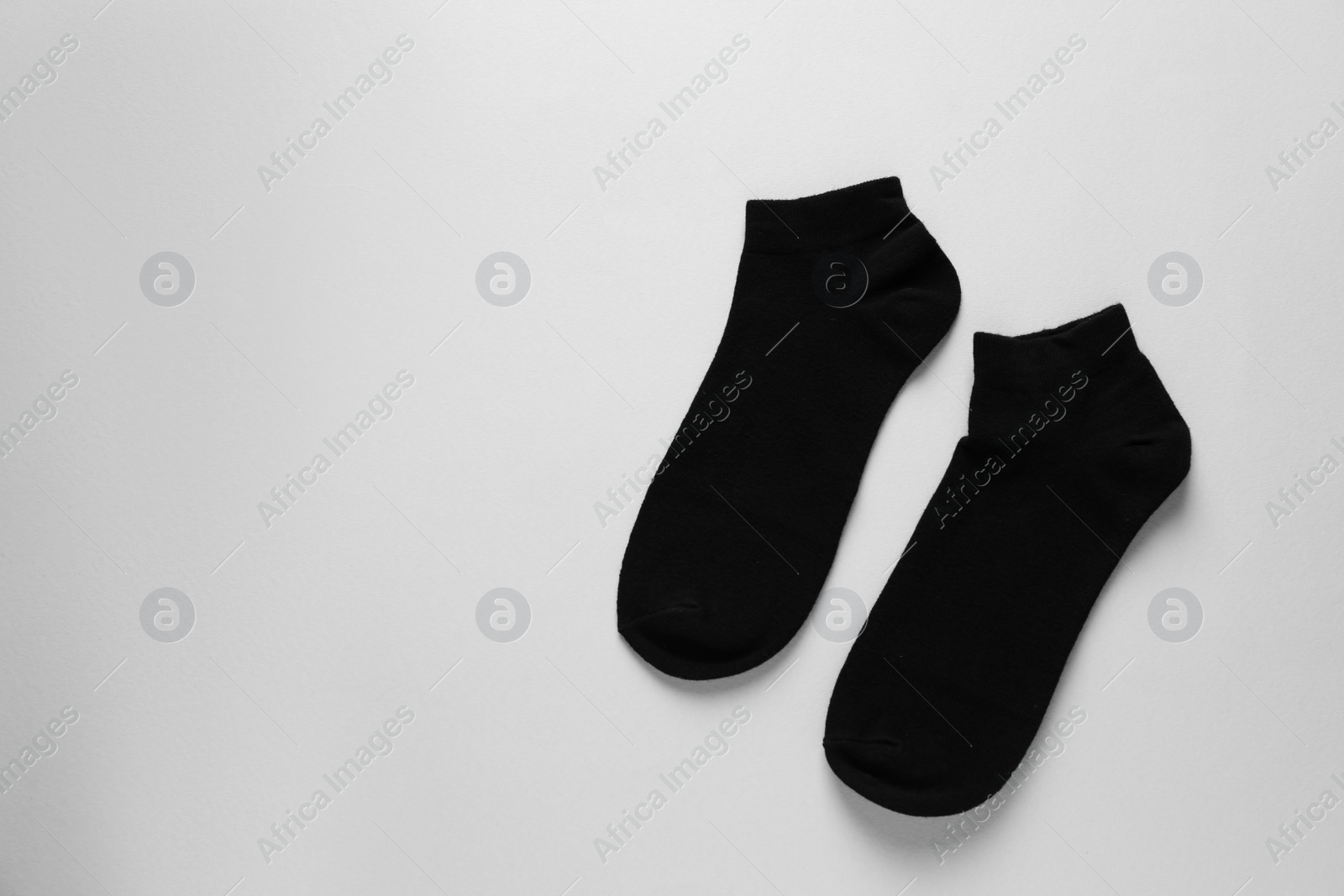 Photo of Pair of black socks on light grey background, flat lay. Space for text