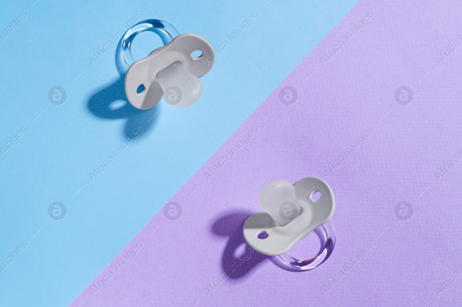 Photo of New baby pacifiers on color background, flat lay