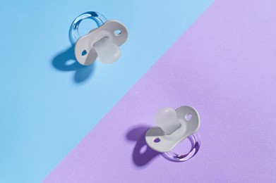 Photo of New baby pacifiers on color background, flat lay