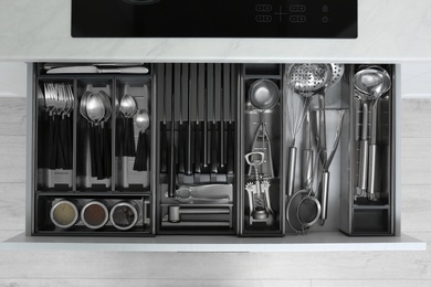 Photo of Drawer with stainless steel utensil set, top view. Order in kitchen