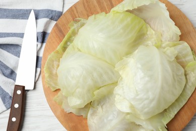 Photo of Cooked leaves for stuffed cabbage roll on white wooden table, flat lay