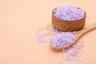 Photo of Bowl and spoon with violet sea salt on beige background, space for text