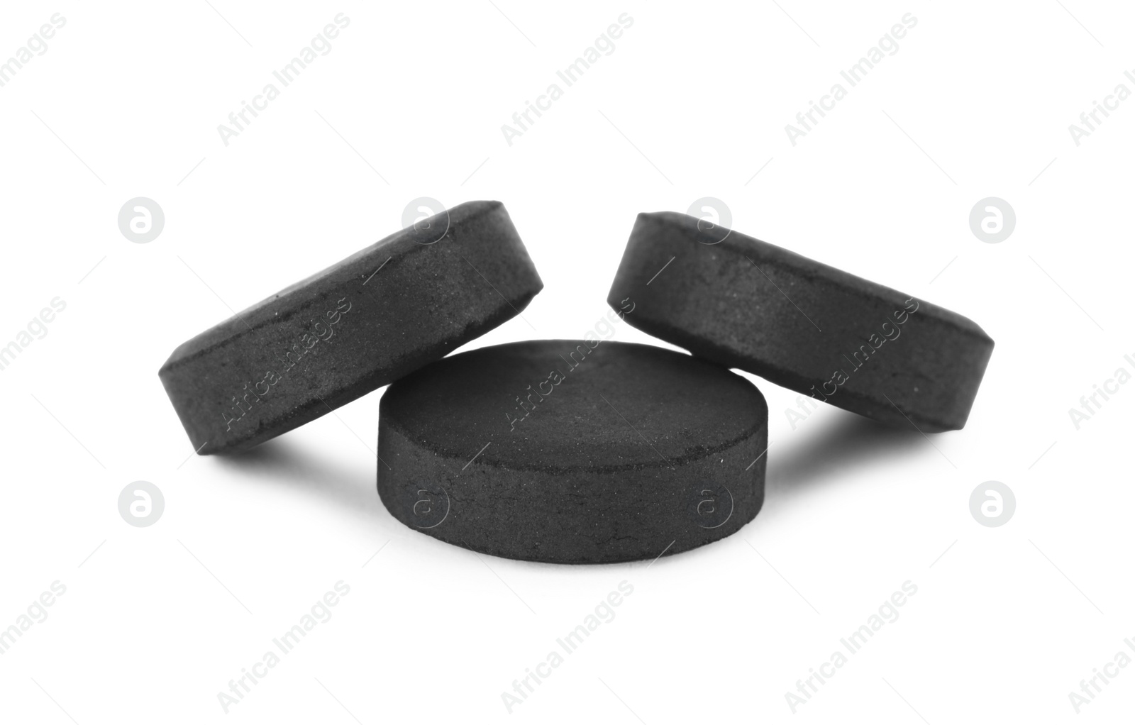 Photo of Activated charcoal pills on white background. Potent sorbent