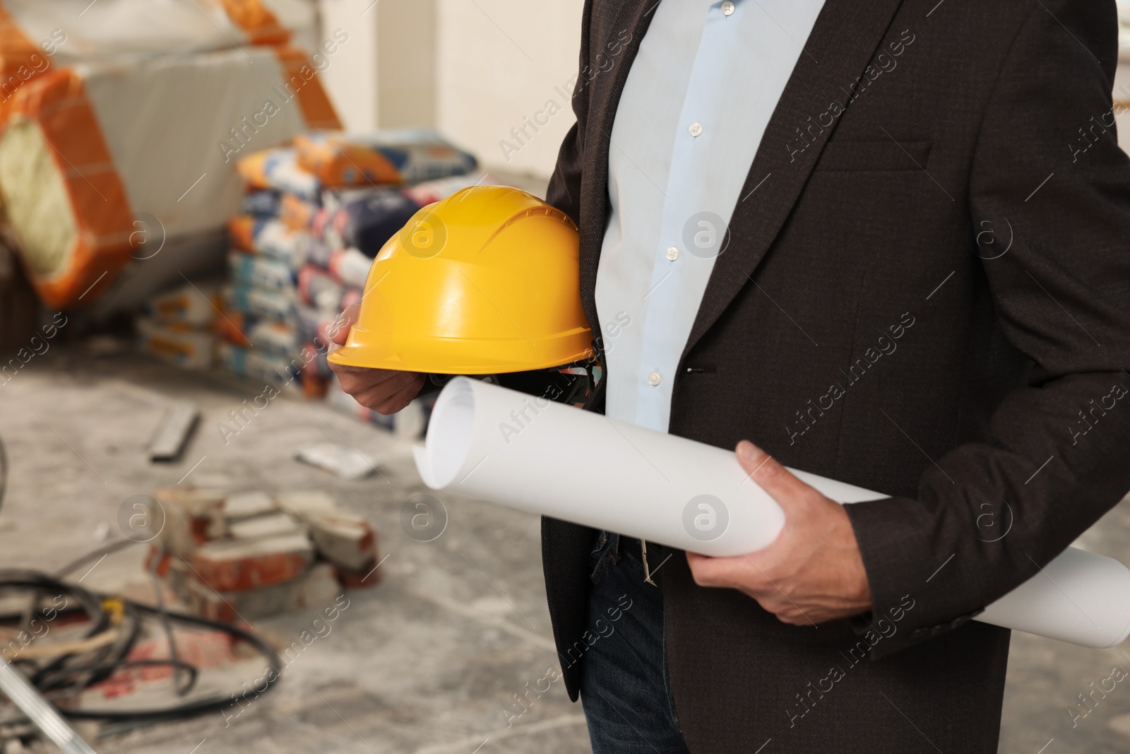 Photo of Professional engineer with hard hat and draft indoors, closeup
