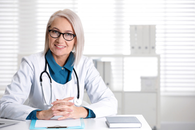 Photo of Portrait of mature female doctor in white coat at workplace