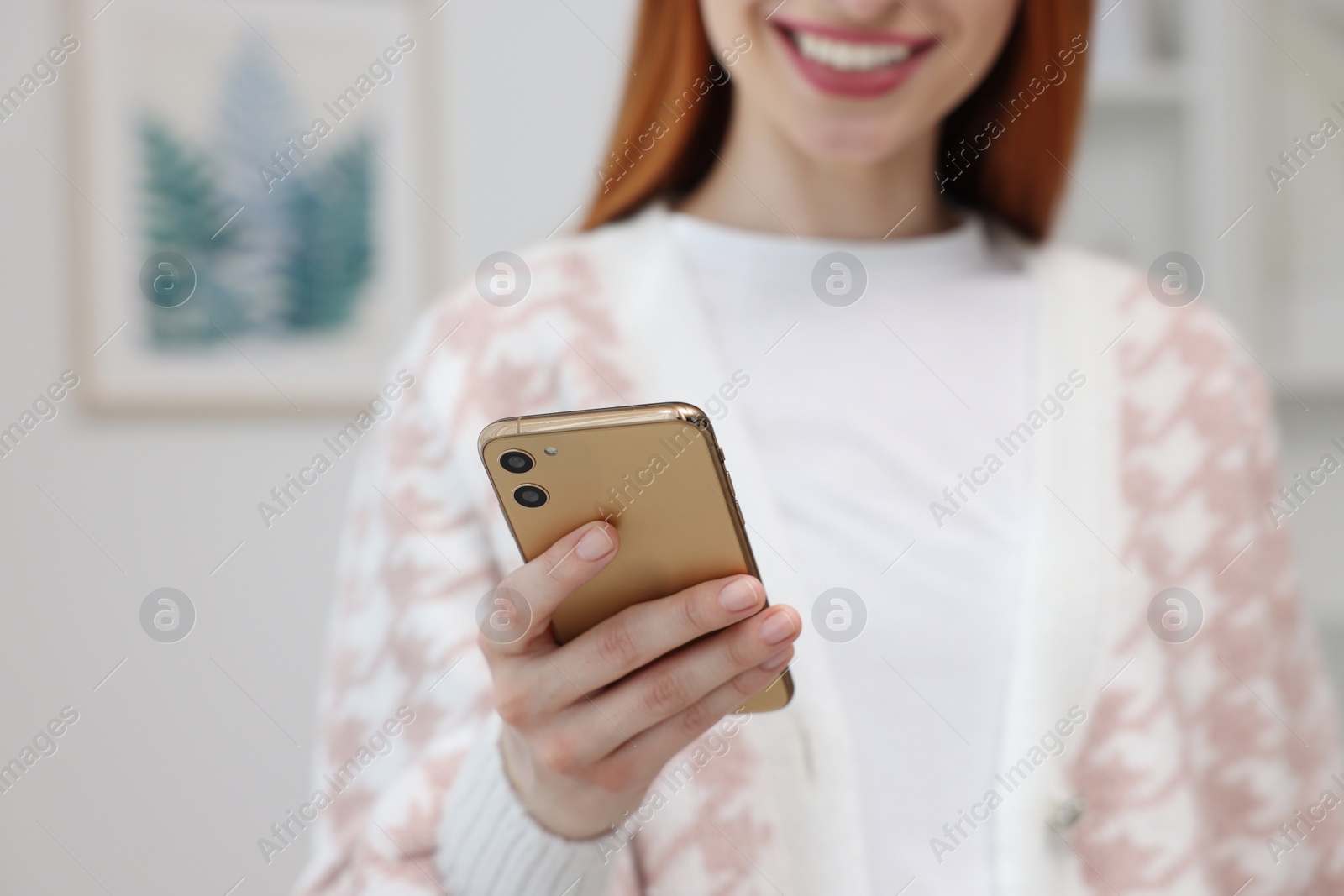 Photo of Woman sending message via smartphone indoors, closeup