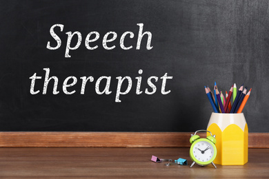 Image of Pencils, alarm clock and text Speech Therapist written on blackboard