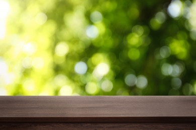 Image of Empty wooden surface against blurred green background. Space for design