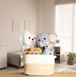 Set of different cute toys on wooden table in children's room