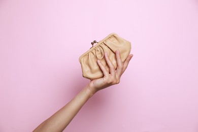 Photo of Woman holding leather purse on pink background, closeup