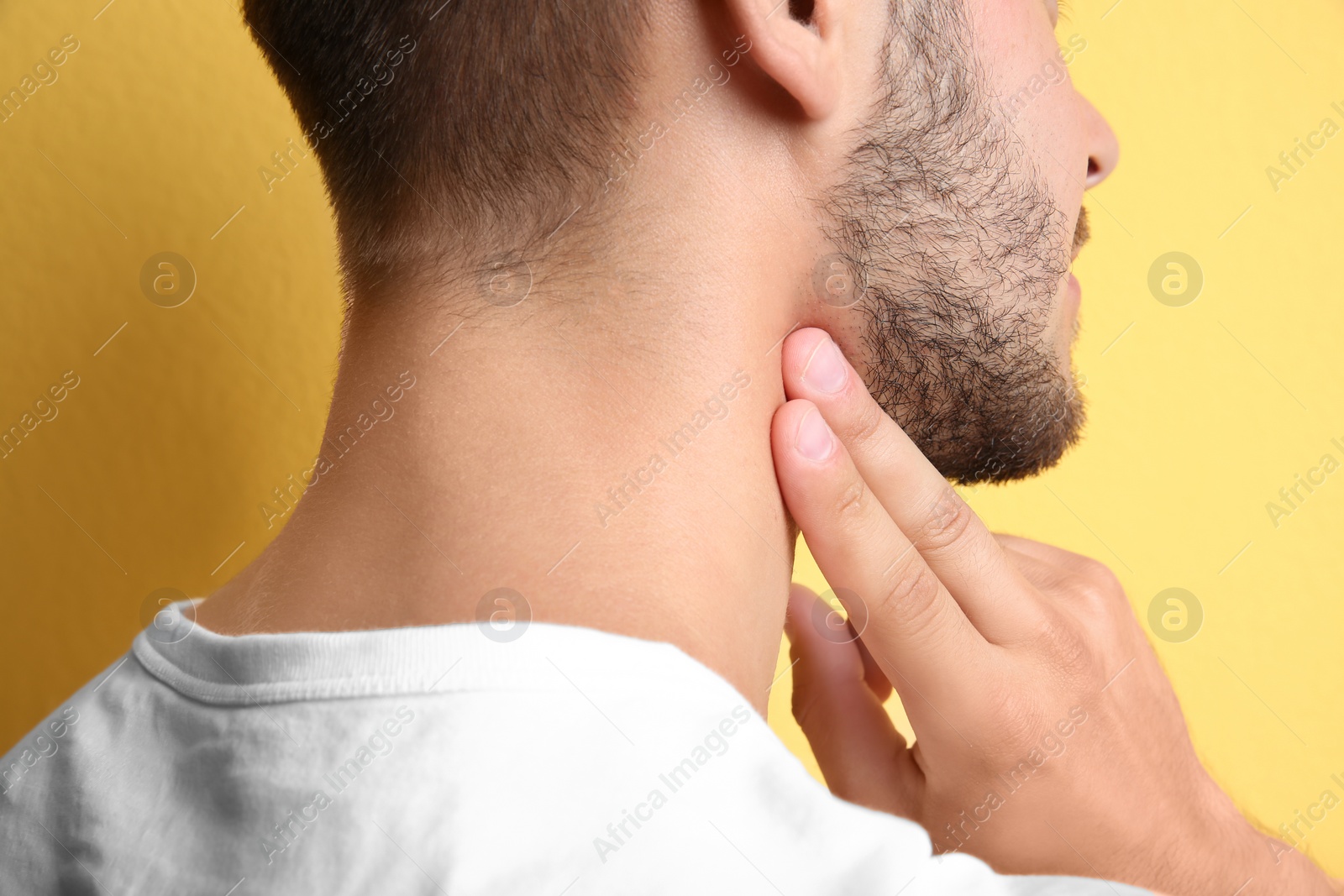 Photo of Young man checking pulse on color background