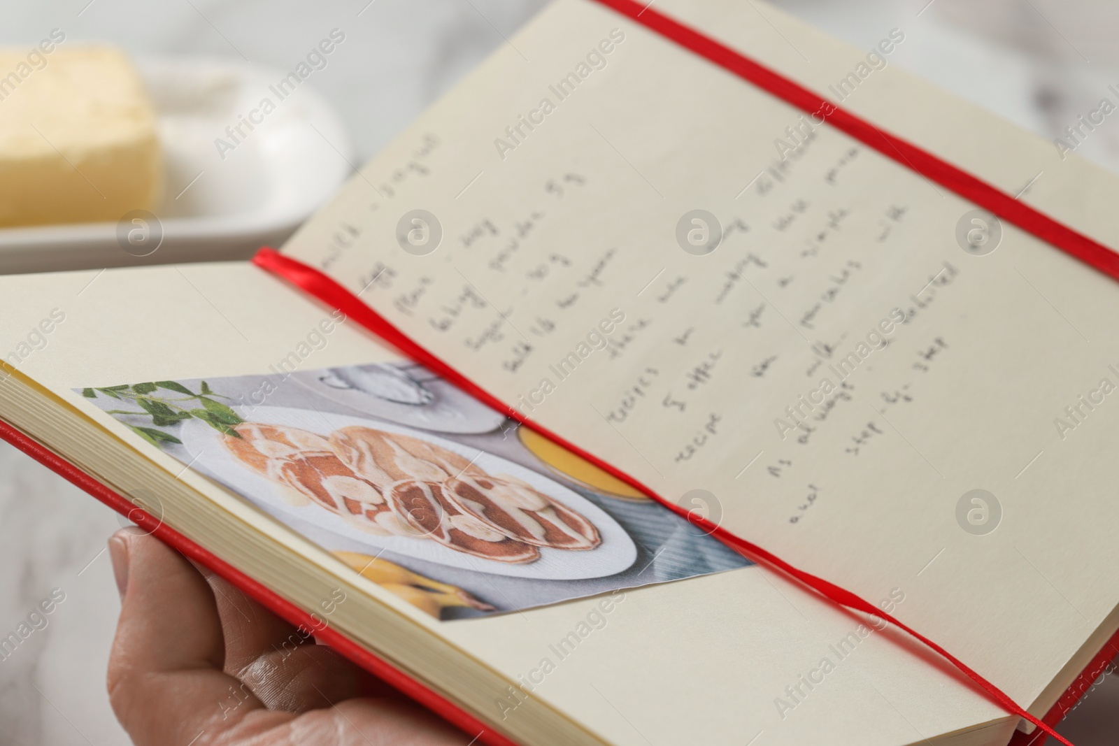 Photo of Man with recipe book at table in kitchen, closeup