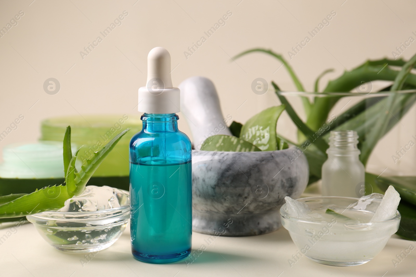 Photo of Cosmetic products and fresh aloe on beige background, closeup