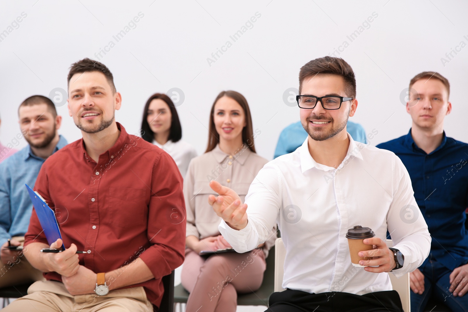 Photo of Young man asking question at business training indoors