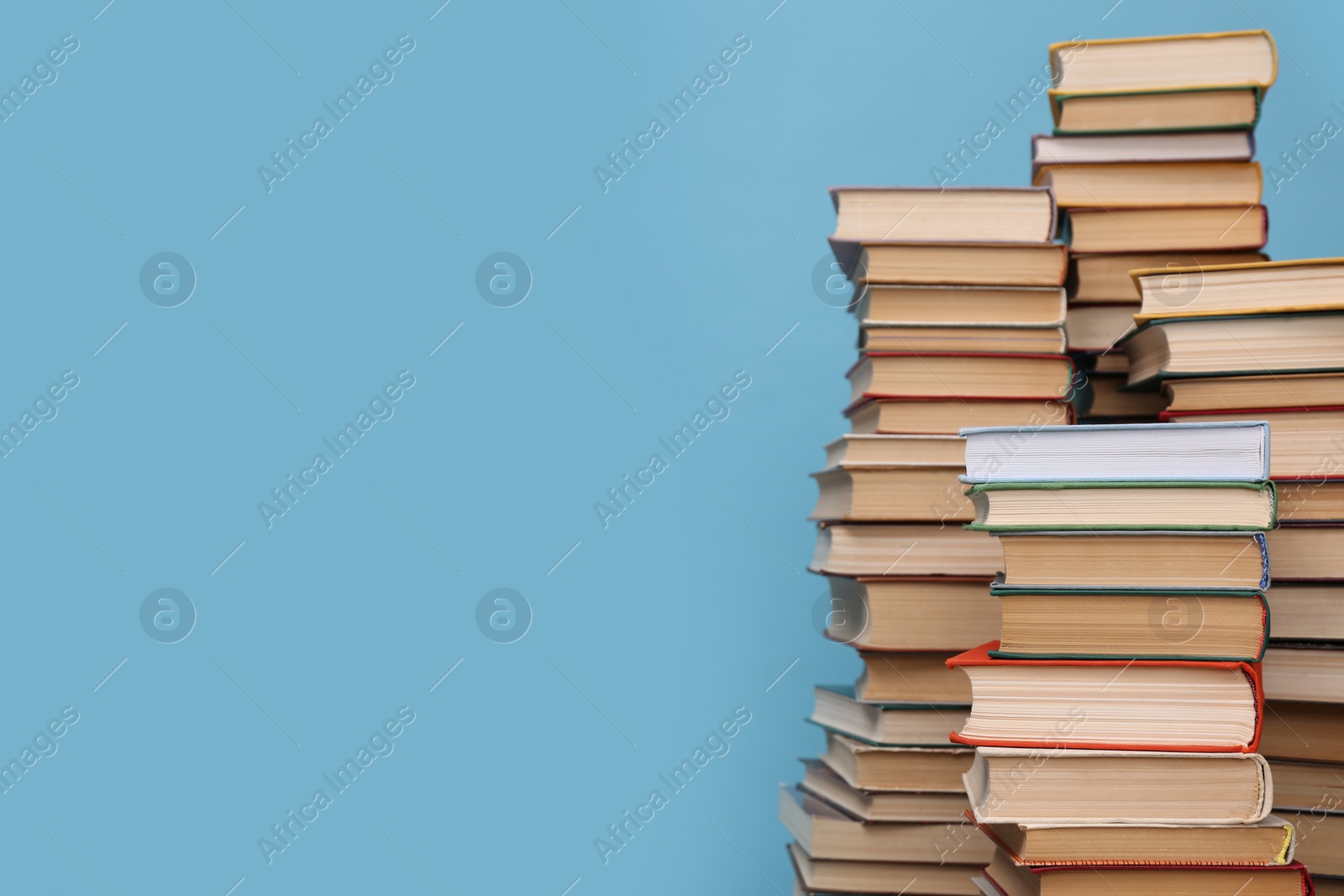 Photo of Many hardcover books on turquoise background, space for text. Library material