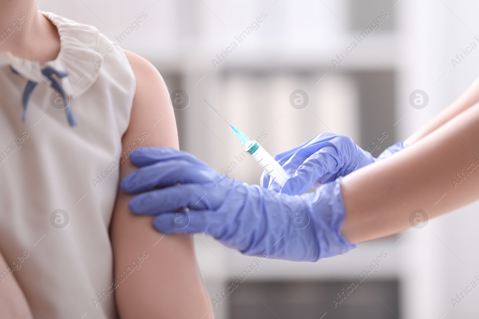 Photo of Little girl receiving chickenpox vaccination in clinic. Varicella virus prevention