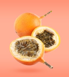 Image of Delicious ripe granadillas falling on coral background