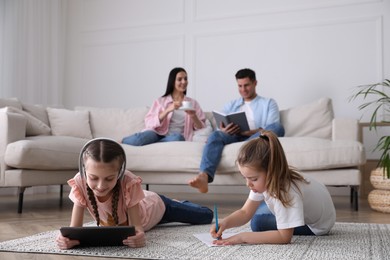 Photo of Family in living room with comfortable sofa, focus on children