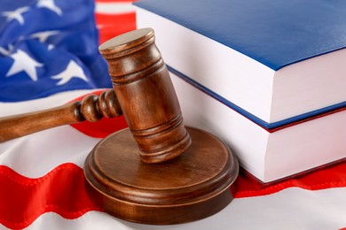 Photo of Judge's gavel and books on American flag, closeup