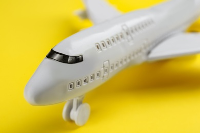 Photo of Toy airplane on yellow background, closeup view