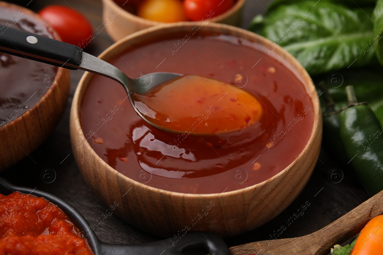 Photo of Taking homemade marinade from bowl at table, closeup