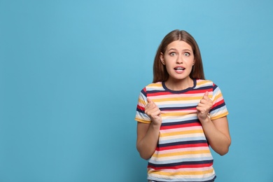 Photo of Portrait of hopeful young woman on light blue background, space for text