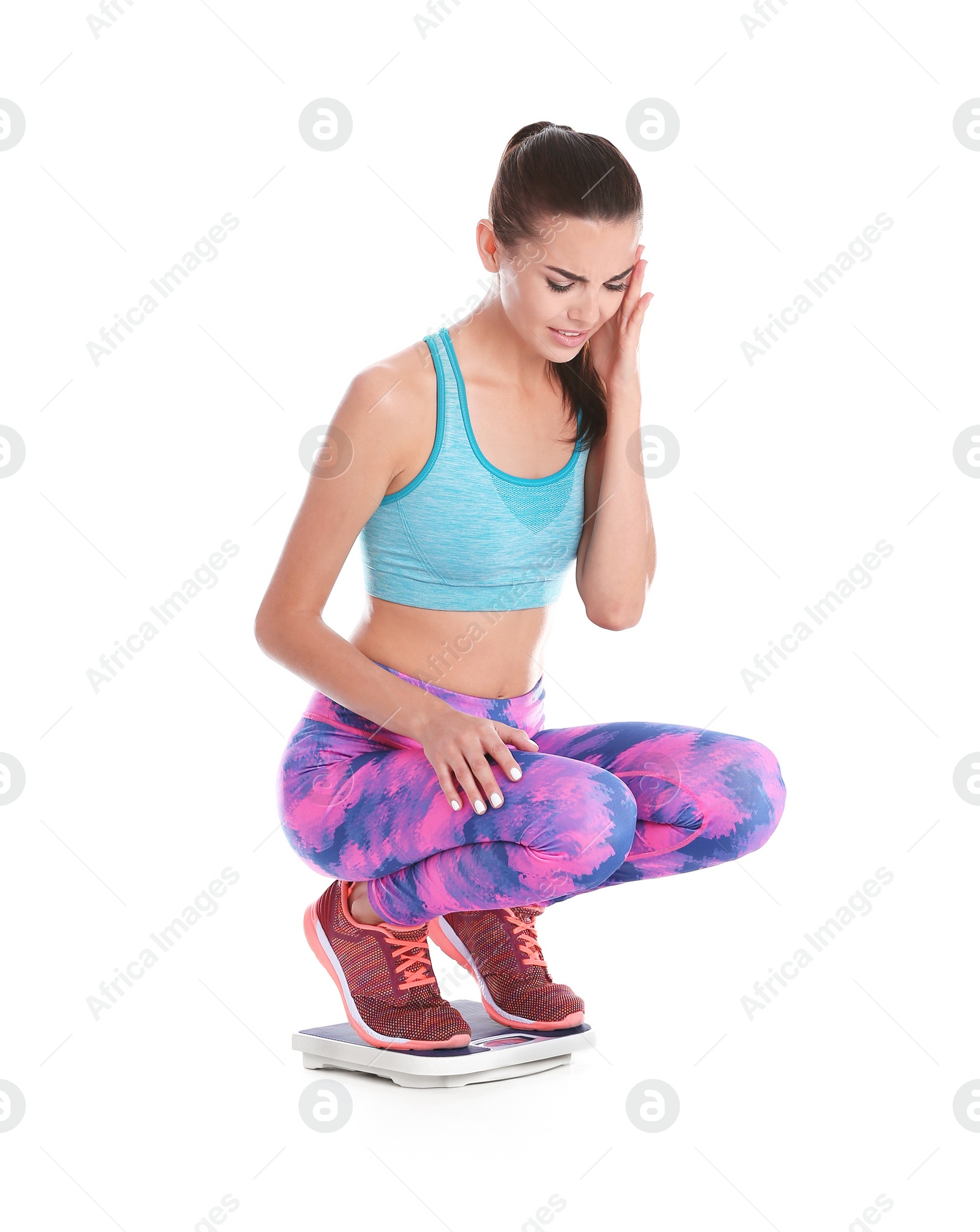 Photo of Young woman measuring her weight using scales on white background. Weight loss motivation