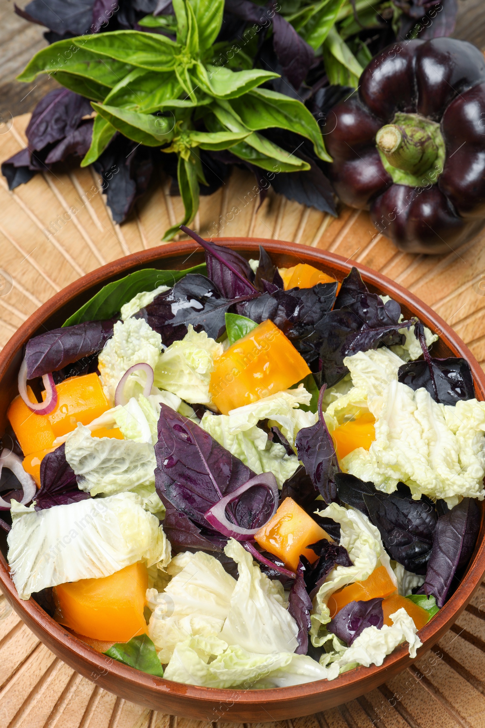 Photo of Delicious salad with Chinese cabbage, tomato and basil served on wooden table, above view