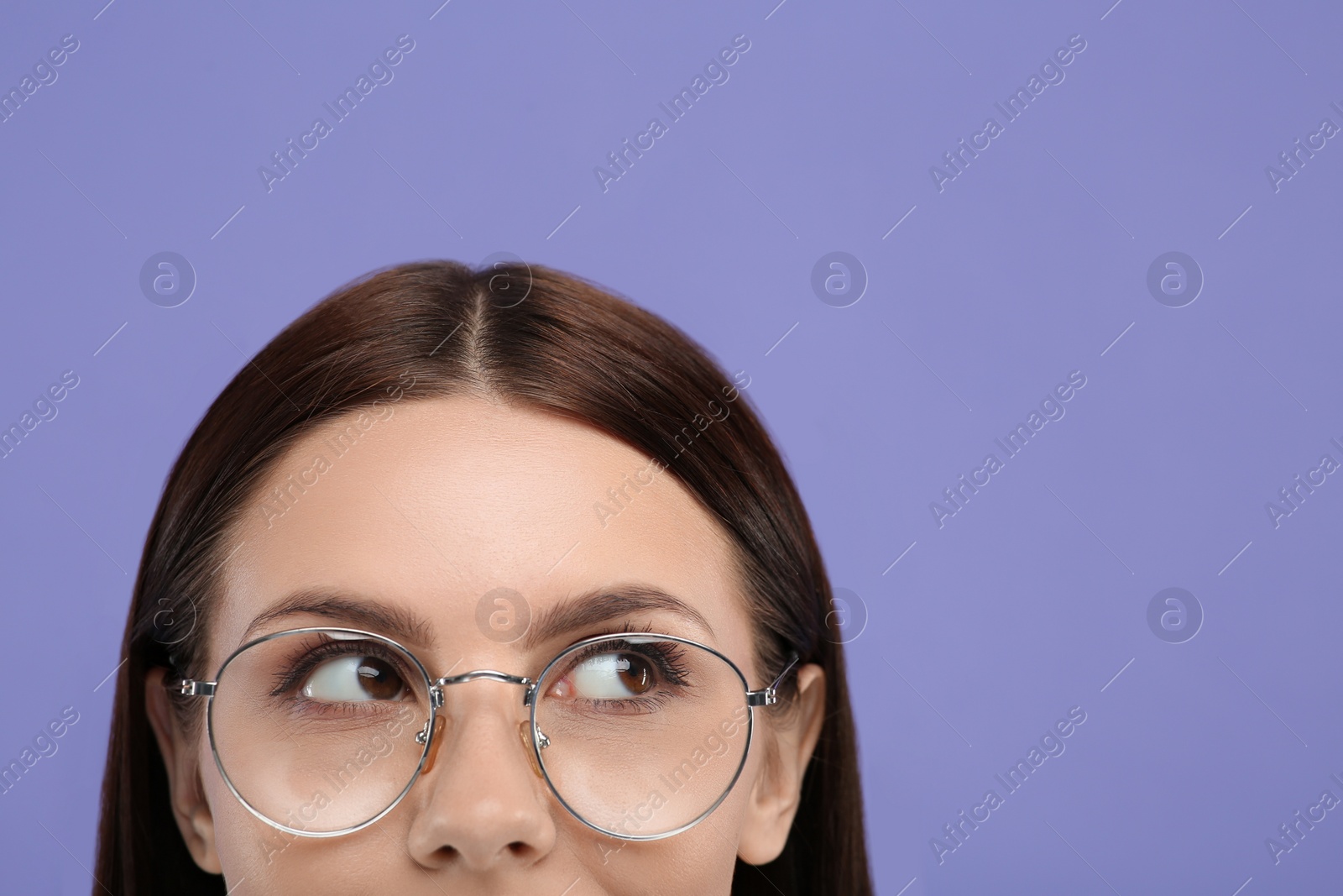 Photo of Woman in stylish eyeglasses on violet background, closeup. Space for text