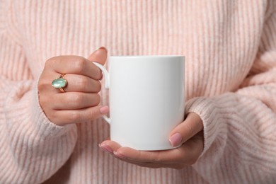 Photo of Woman holding white mug, closeup. Mockup for design