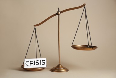 Photo of Scale with word Crisis on beige background