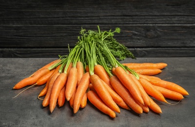 Photo of Ripe carrots on grey table. Healthy diet