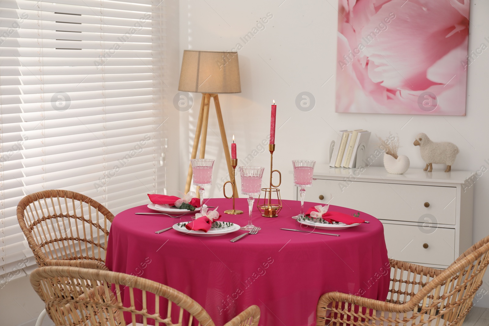 Photo of Beautiful table setting with green branches and burning candles in dining room