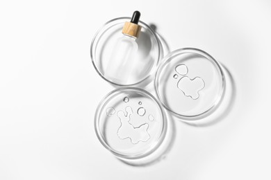 Photo of Petri dishes with sample and bottle on white background, top view