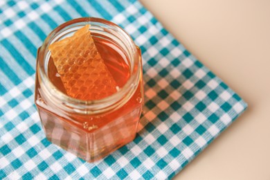Photo of Jar with honey and combs on light table, space for text