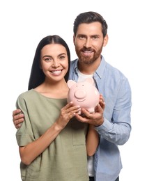 Happy couple with ceramic piggy bank on white background