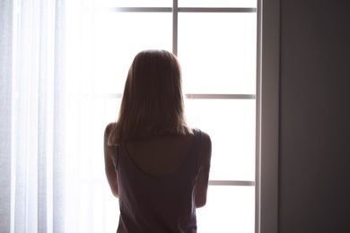 Lonely woman near window at home. Depression
