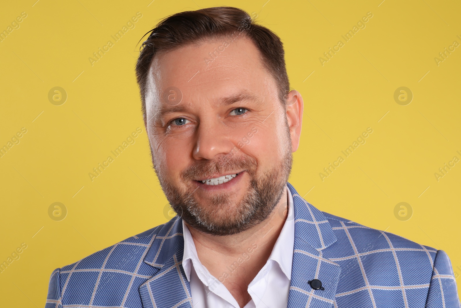 Photo of Portrait of happy mature man on yellow background