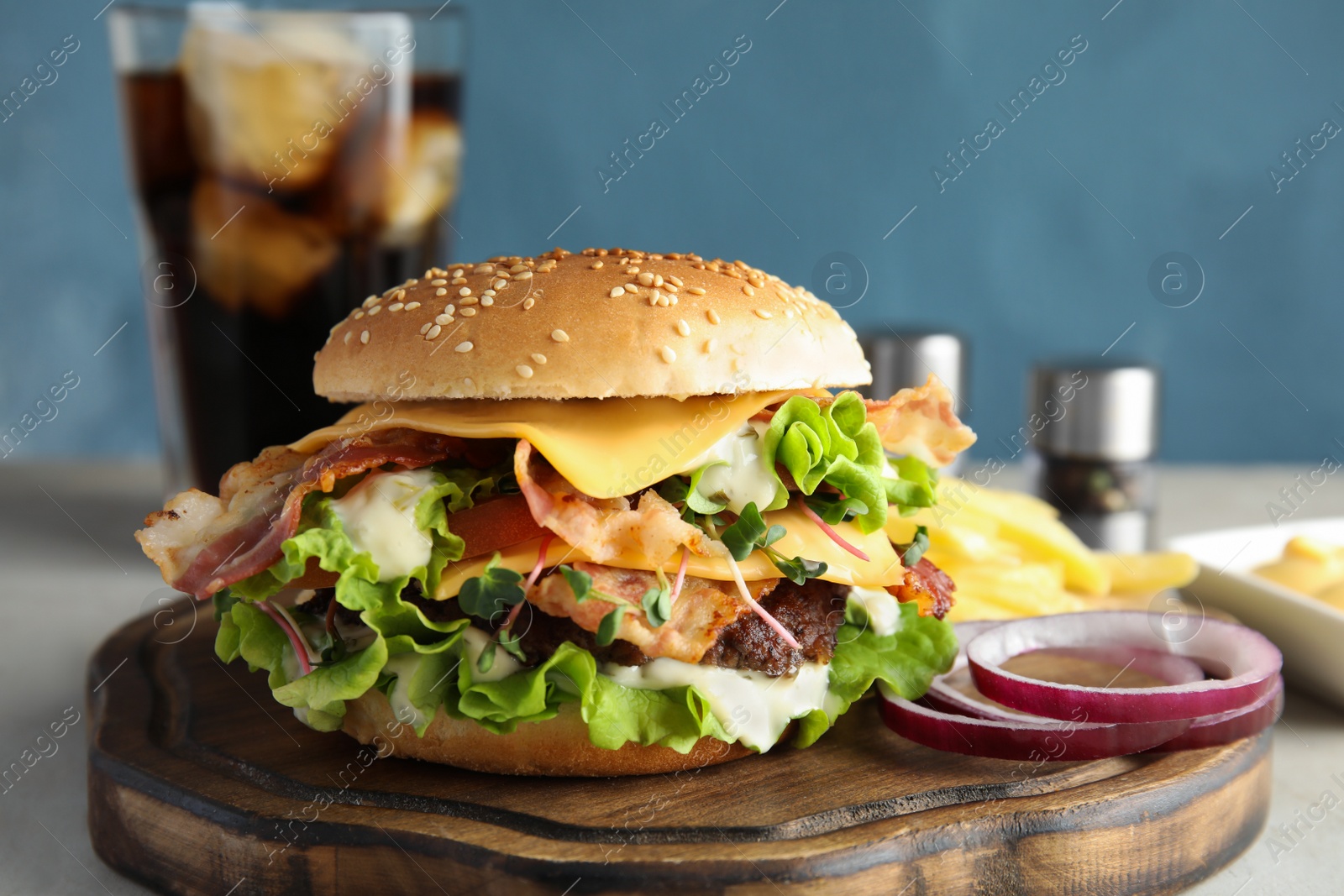 Photo of Tasty burger with bacon served on board