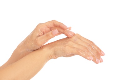 Young woman applying natural scrub on hands against white background