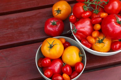Photo of Bowls with fresh tomatoes on wooden table, flat lay. Space for text