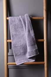 Photo of Soft terry towel on wooden ladder indoors