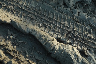 Photo of Ground mud with tire tracks as background, closeup