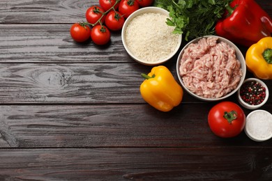 Photo of Making stuffed peppers. Ground meat and other ingredients on wooden table, flat lay. Space for text