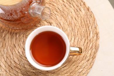 Aromatic tea in cup and teapot on table, top view