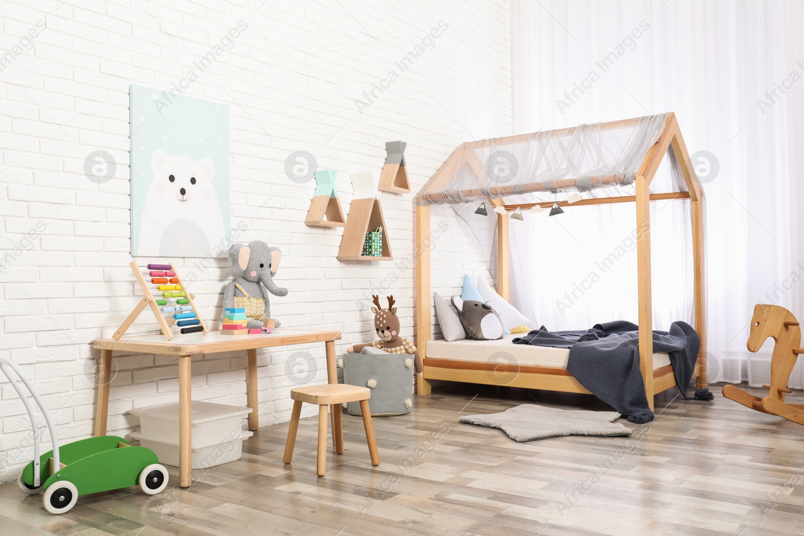 Photo of Cute child's room interior with toys and modern furniture