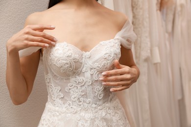 Woman trying on wedding dress in boutique, closeup