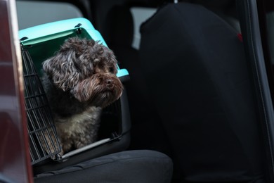 Photo of Cute dog in pet carrier travelling by car, space for text. Safe transportation